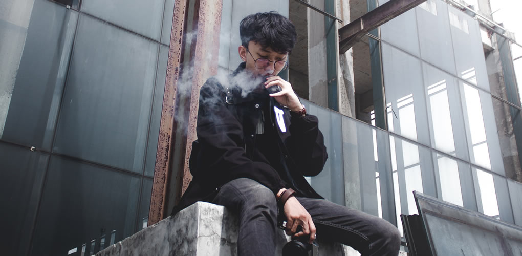 man sat on building vaping